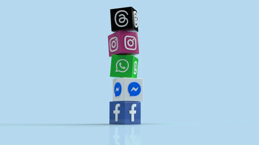 A vertical stack of colorful 3D blocks arranged from top to bottom featuring Meta social media logos: Threads, Instagram, WhatsApp, Messenger, and Facebook, set against a light blue background. This is in "Facebook and Instagram Shopping Image Requirements Scaled" article in Dropicts.com website