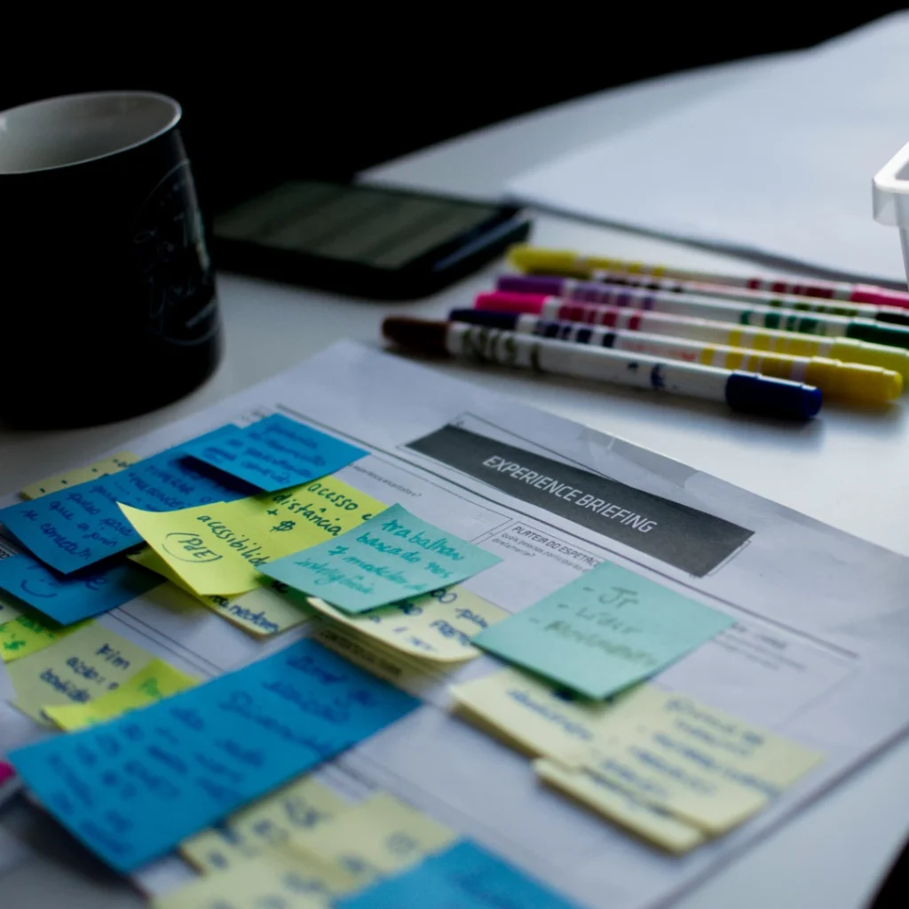 Sticky notes and several pen on top of a table in "Photo Editing Brief Instructions" article in Dropicts.com website