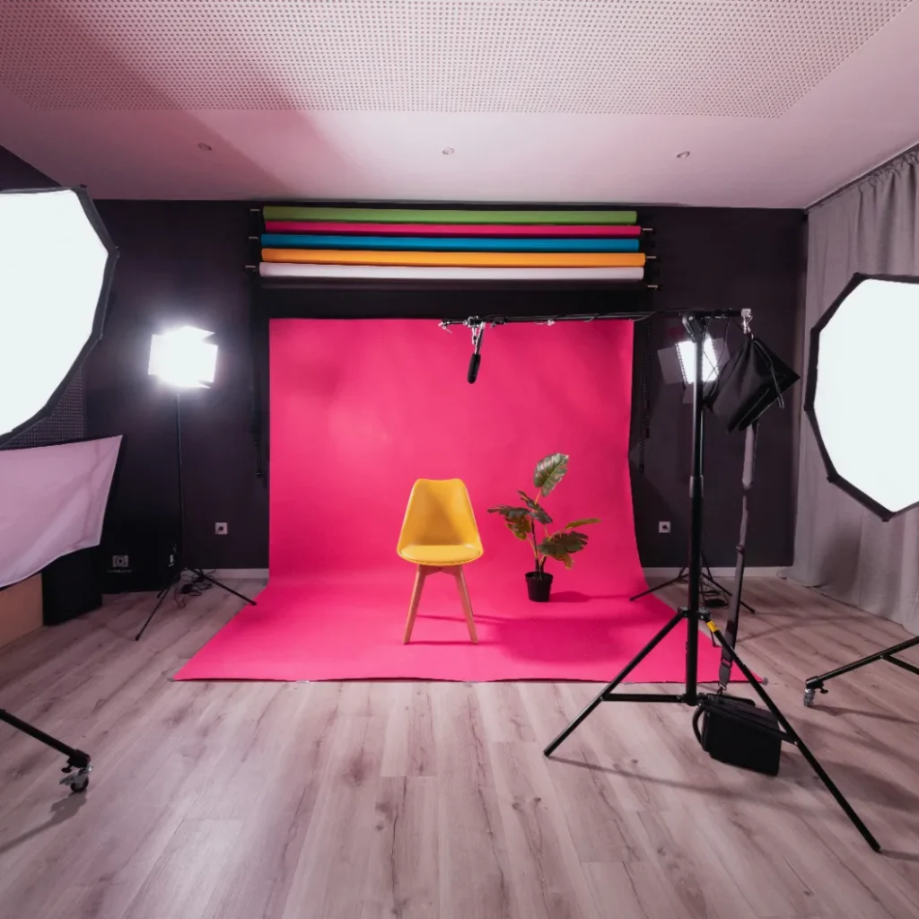 Photo studio setup with pink backdrop and lighting on each side in the Product Photography Backdrop article in Dropicts.com