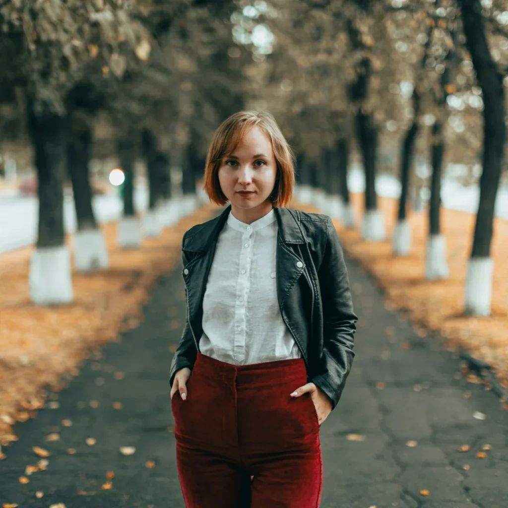 A woman wearing white shirt, black jacket, and red pants in the Seasonal Color Trends article in Dropicts.com